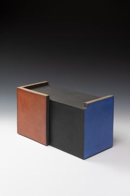 une image représentant une boîte noire, bleue et marron posée sur une surface blanche
