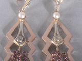pair of earrings with pearls and diamonds on a silver background