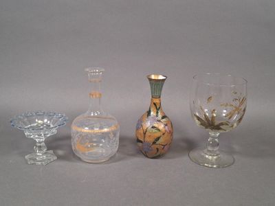 trois vases en verre différents et un verre à vin posés sur une table