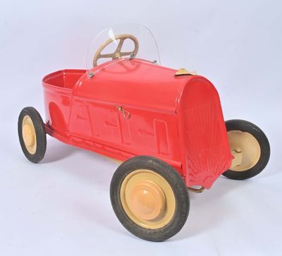 a red toy car that is sitting on a white surface