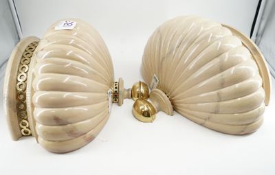 two shell shaped purses sitting on a white table