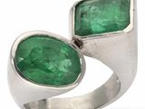 un gros plan d'une bague sertie de deux émeraudes