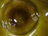a close up view of a yellow vase with a label on it