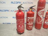 fire extinguisors are lined up in a row on a table