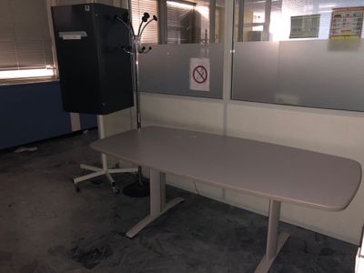 une table sur laquelle est posé un panneau, dans un bureau