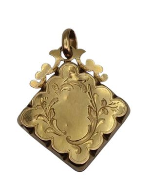 an image of a gold pendant with a picture of a bird on it