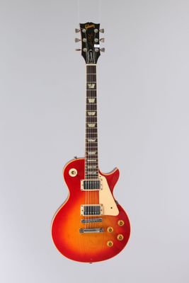 une guitare électrique accrochée à un mur sur fond blanc