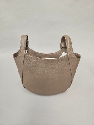 a small beige purse with a handle on a white background
