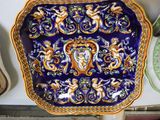 une assiette bleue et dorée sur laquelle est représentée une femme