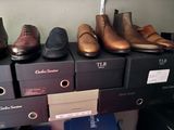 Plusieurs paires de chaussures pour homme sont alignées sur une étagère