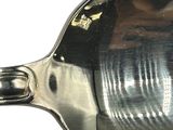 a silver spoon with a handle on a white surface