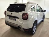 the rear end of a white car parked in a garage
