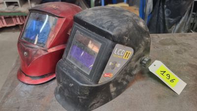 two welding helmets sitting next to each other on a table