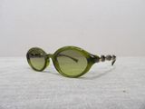 green sunglasses on a white table with a white table cloth