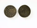 two coins are shown on a white surface with a white background