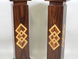 pair of wooden pedestals with gold designs on them on a white background