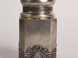 une salière ancienne en argent posée sur une surface blanche