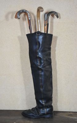 a tall boot that has a bunch of umbrellas in it