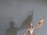 a statue of a man holding a flag and a flag pole