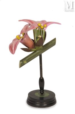 un petit vase orné d'une fleur, posé sur un socle