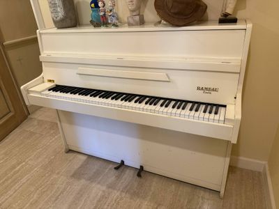 a white piano in the corner of a room