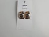 une paire de boucles d'oreilles en or sur une carte blanche