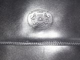 a close up of a black purse with a crest on it