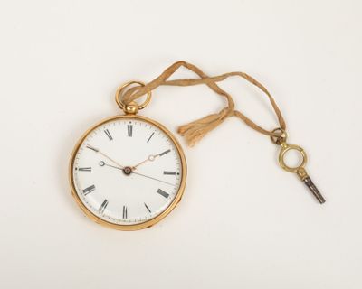 a gold pocket watch with a key attached to it