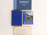 an open book sitting on top of a table next to a blue book