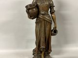 bronze statue of a woman holding a pot and a jug