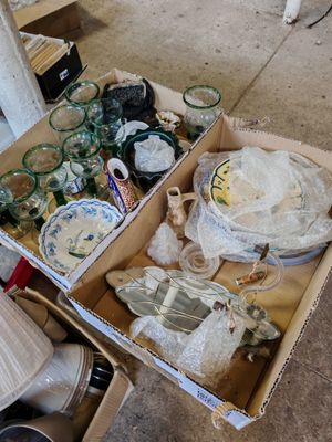 une boîte remplie d'objets divers posée par terre