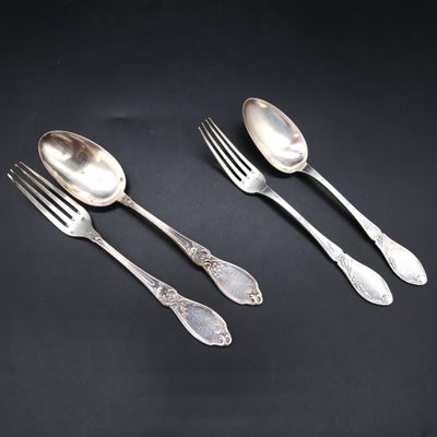 three silver spoons and two forks on a black surface