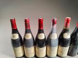 six bottles of wine are lined up in a row on a table