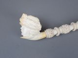 a white pipe with a carved head on top of it