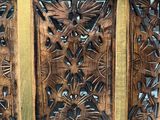 carved wood panel with a pattern of leaves and flowers