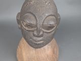 une petite statue représentant un homme, posée sur un socle en bois