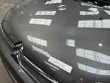a black car with a sticker on it parked in a parking lot