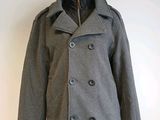 grey peale coat on a mannequin stand against a white wall