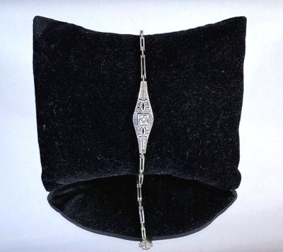 an image of a black velvet case with a silver bracelet on it