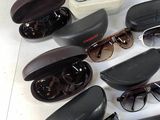 many pairs of sunglasses sitting on a white surface