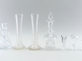 several clear glass vases are lined up on a white surface
