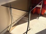 a glass table with a chair in front of a window