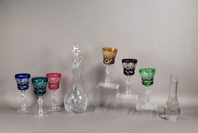 plusieurs vases en verre de différentes couleurs sont alignés sur une surface blanche