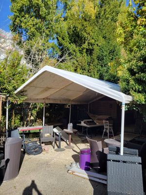 a white canopy over a table and chairs in a yard