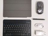 a keyboard, mouse, mouse pad, and other electronics laid out on a table