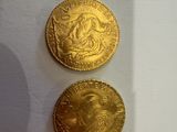 deux pièces d'or posées l'une à côté de l'autre sur une surface blanche