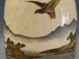 an image of a vase with a bird on it on a table