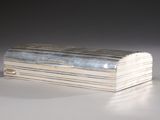 an antique silver box with a lid on a white surface