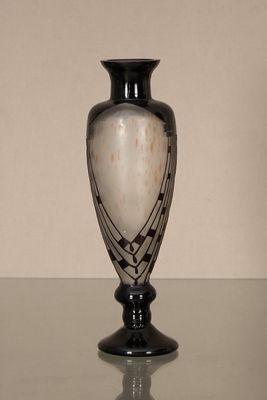 un vase noir et blanc posé sur une table en verre