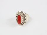 un gros plan d'une bague en argent sertie d'une pierre rouge